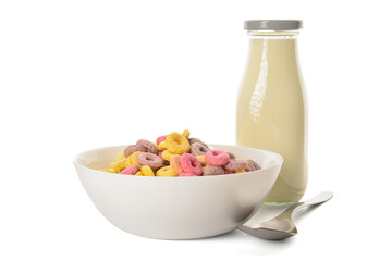 Bowl with colorful sweet cereal rings and bottle of milk on white background
