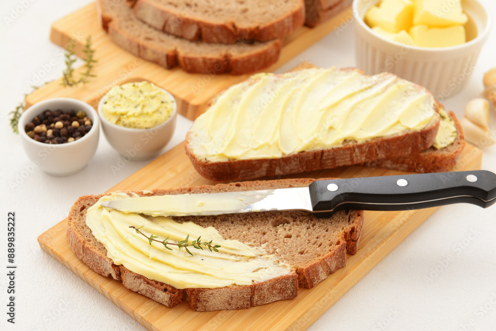 Wall mural Wooden board of bread slices with fresh butter and bowl of peppercorn on white background