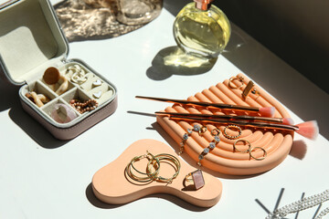 Box and stands with stylish different jewelry on table, closeup