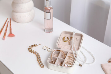 Box with stylish different jewelry on dresser, closeup