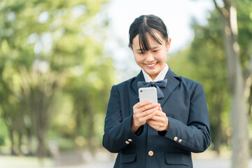 スマホを見て驚く・喜ぶ制服姿・ブレザー姿の女子中学生・女子高校生
