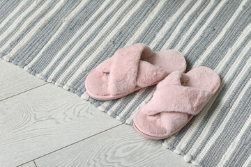 Pink slippers on rug in room, closeup