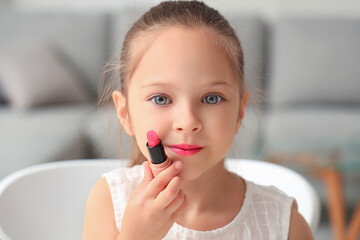 Cute little girl with lipstick in living room