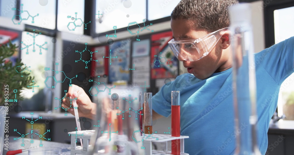 Poster chemical formulas and molecular structures over boy conducting science experiment in lab image