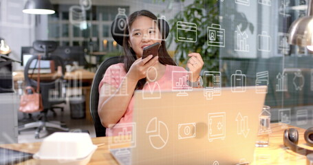 Image of business icons and data processing over biracial businesswoman in office