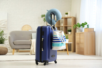 Neck pillow on suitcase with beach bag in bedroom. Travel concept