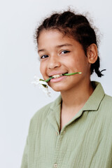 Trendy young african american boy posing with a flower in his mouth for a stylish portrait
