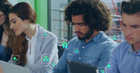Image of ecology icons over diverse colleagues using technology in office