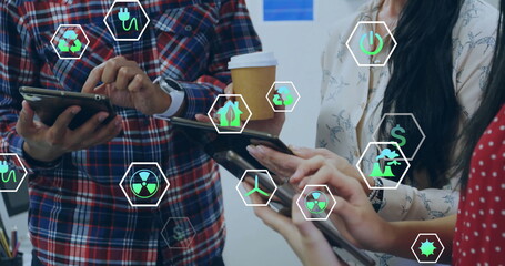 Image of ecology icons over diverse colleagues using tablet in office