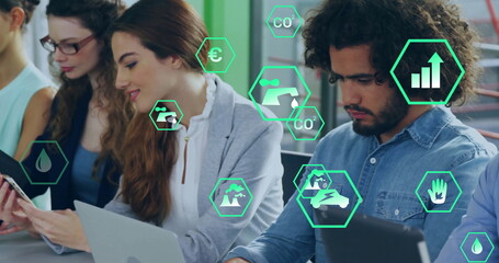 Image of ecology icons over diverse colleagues using technology in office