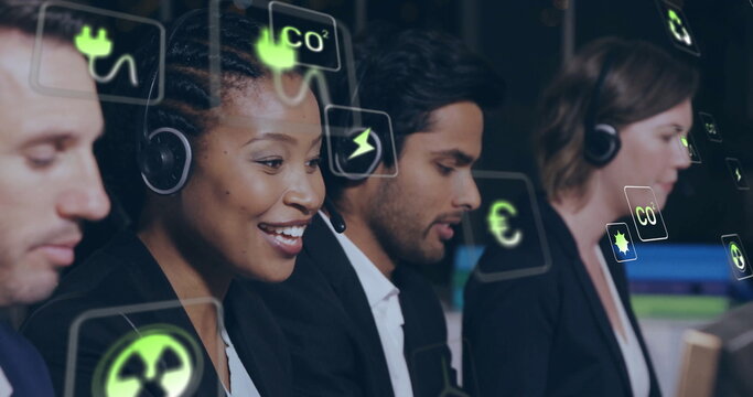 Image of ecology icons over diverse colleagues using phone headset in office