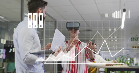 Image of media icons processing data over diverse colleagues using vr headset at casual office