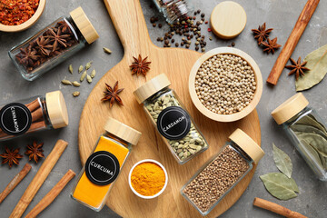 Labelled jars with spices on grey table, flat lay