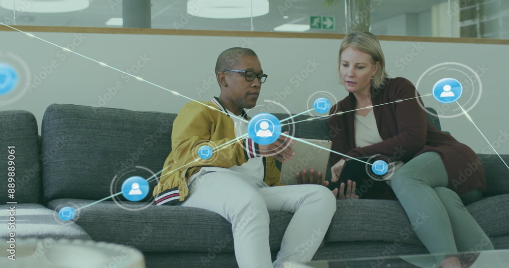 Poster image of network of connections with icons over diverse colleagues using tablet in office