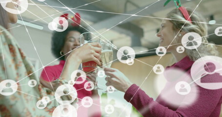 Image of network of connections with icons over diverse colleagues celebrating in office