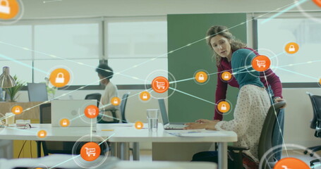 Image of network of connections with icons over diverse female colleagues using laptop in office