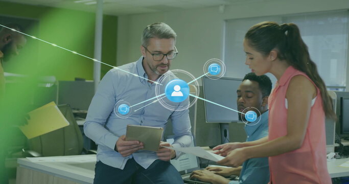 Image of network of connections with icons over diverse colleagues using tablet in office