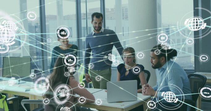 Image of network of connections with icons over diverse colleagues using laptop in office