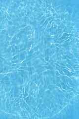 Blue water with ripples on the surface. Defocus blurred transparent blue colored clear calm water surface texture with splashes and bubbles. Water waves with shining pattern texture background.	