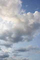 It's a blue sky with atmospheric puffy clouds.