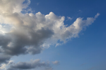 It's a blue sky with atmospheric puffy clouds.