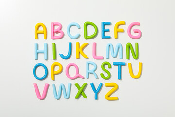 Alphabet made of colored plasticine on a light background.
