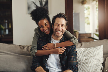 Happy, hug and couple with portrait on sofa for weekend bonding, interracial and romance together....