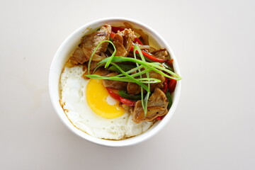 A bowl of food with meat and eggs