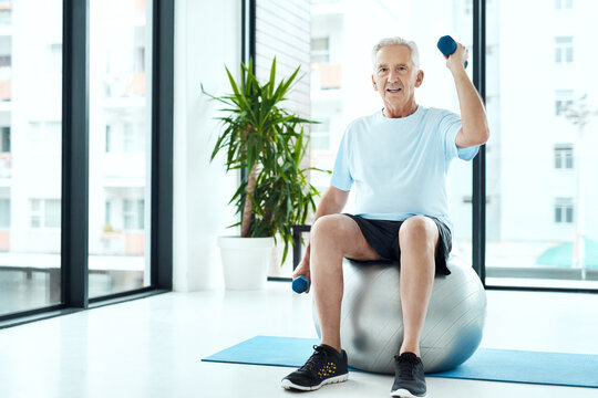 Fitness, portrait and elderly man with dumbbells in clinic for physiotherapy, rehabilitation or wellness. Health, strength and senior person with ball for mobility training, recovery or weightlifting