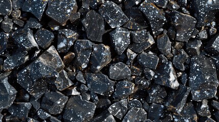 Black and white speckled stones. The photo features a close up shot of black and white speckled stones, perfect for use as a background or texture in design projects.