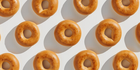 A background of bagels with cream cheese, each with its shadow, scattered across the canvas in an elegant display, with soft shadows on a white background