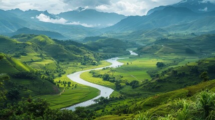 Fototapeta premium A stunning view of a winding river cutting through a lush green valley, with mountains in the background