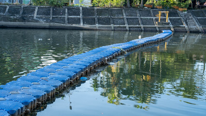 Floating cubes, blue Floating Docks made from HDPE or High-Density Polyethylene are placed in rivers in the city of Padang, Indonesia to prevent rubbish. River environmental concept