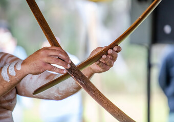 Australian aboriginal ceremony, human hand holds boomerangs for the welcome ritual rite at indigenous community event