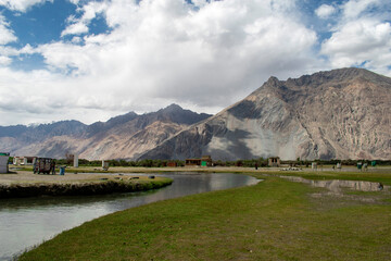 the river with blue sky and sandstone mountains in nubra valley, leh ladakh, india