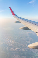 Fototapeta premium View from the airplane window at a beautiful cloudy sky and the airplane wing