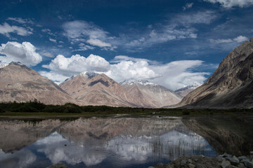 the river with blue sky and sandstone mountains in nubra valley, leh ladakh, india