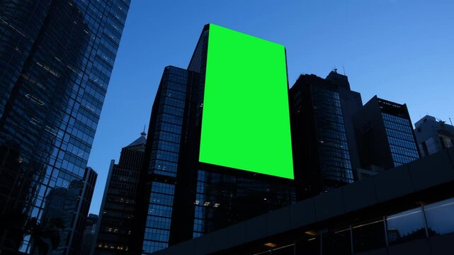 Billboard with green screen on street at night.