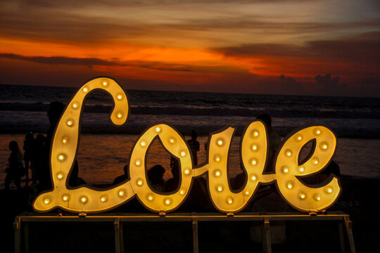 Public Love light up sign on Kuta Beach at Sunset in Bali Indonesia