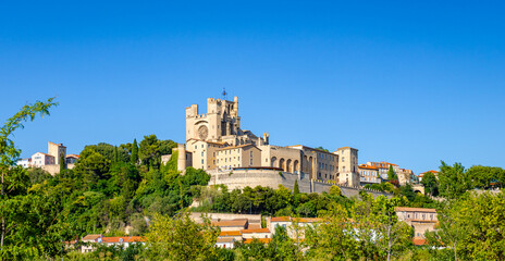 Cathedral Saint-Nazaire-A river runs through a town with a castle in the background