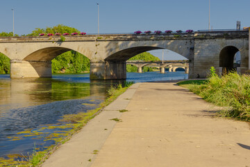 Fototapeta premium Pont Vieux- A bridge spans a river with a castle in the background
