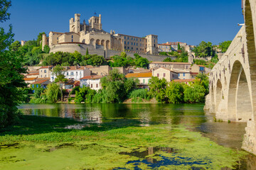 Cathedral Saint-Nazaire-A river runs through a town with a castle in the background