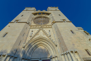 Obraz premium Cathedral Saint-Nazaire-A river runs through a town with a castle in the background