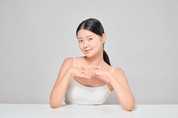 Portrait of an Asian female model with clear and clean skin. Beauty cosmetics female upper body.Clasped hands.