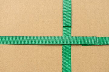 close up of green packaging plastic belt from the cardboard box that shows the connection point