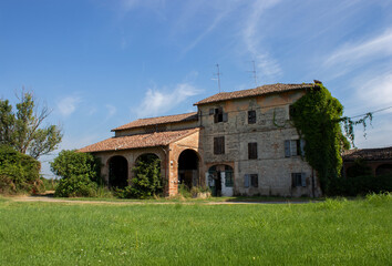 Old deserted farm cottage surrounded by fields.