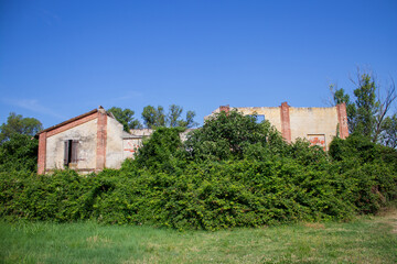 Old deserted farm cottage surrounded by fields.