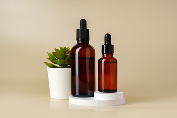 Set of brown glass bottles with essential oils on stand on beige background