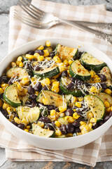 Parmesan Zucchini Corn Black Beans Salad closeup on the bowl on the table. Vertical