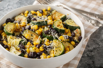 Vegetarian salad of roasted zucchini, black beans, corn, garlic and parmesan close-up in a bowl on the table. Horizontal